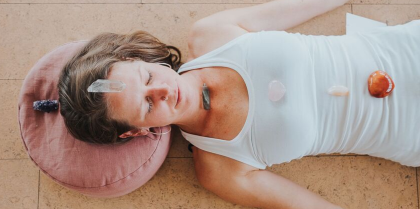 Tash laying down with crystals overtop.