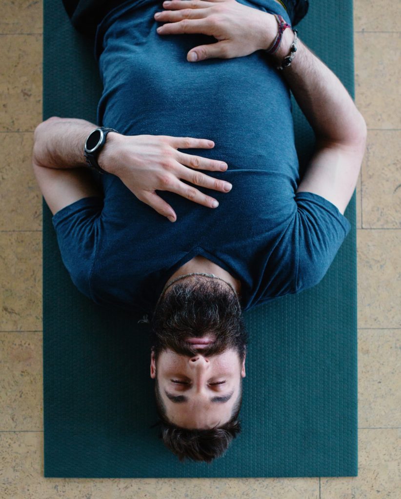 Brad laying down with 1 hand on belly and chest.