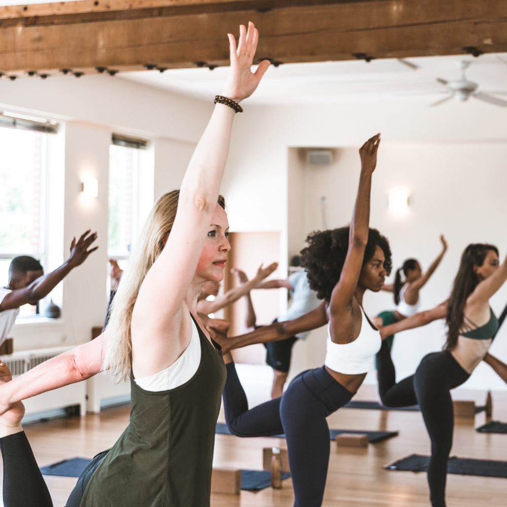 A yoga class stands in dancer's pose