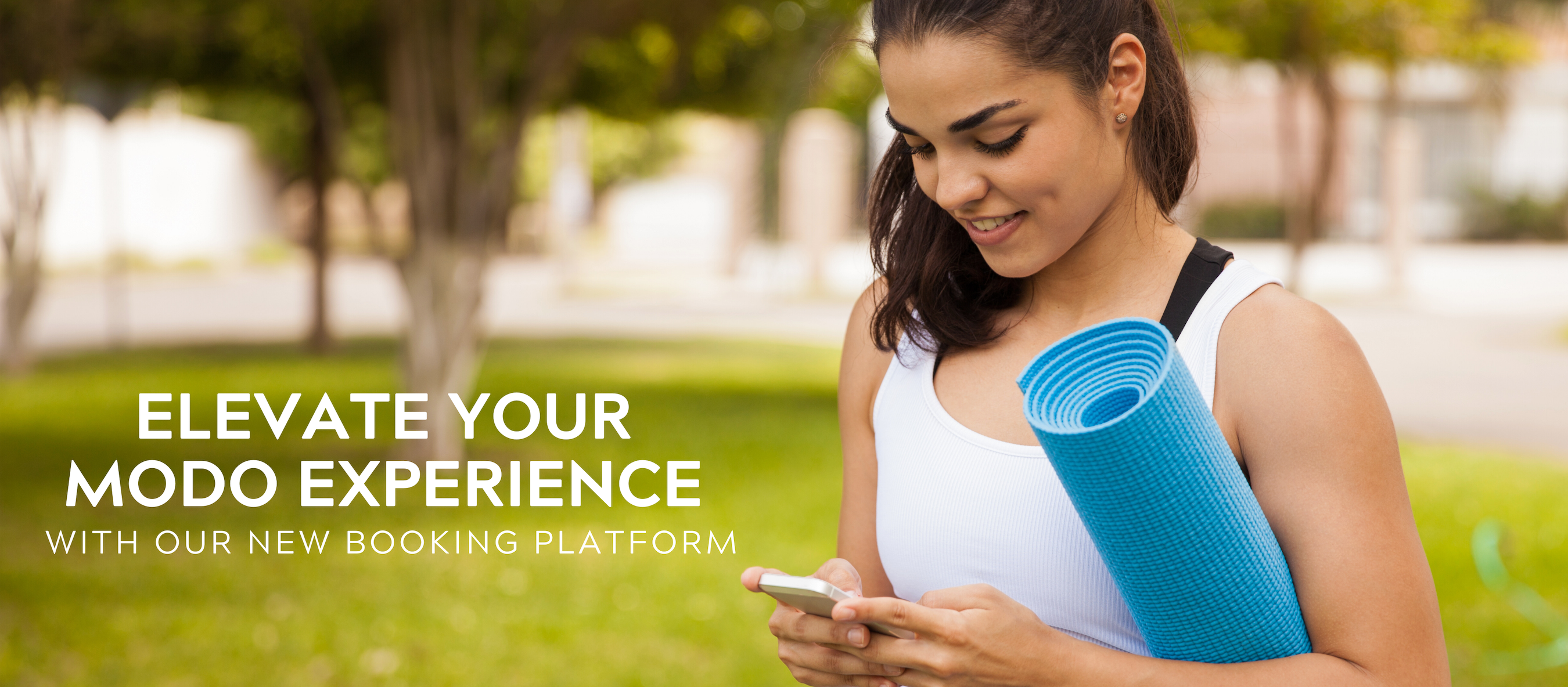 photo of person holding yoga mat and looking at their smart phone