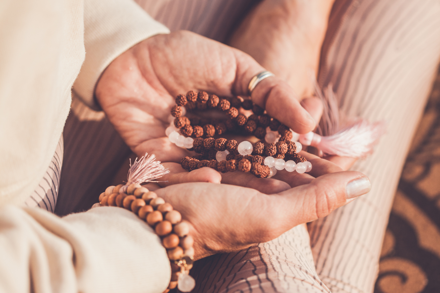 woman's hands holding mala beads necklace